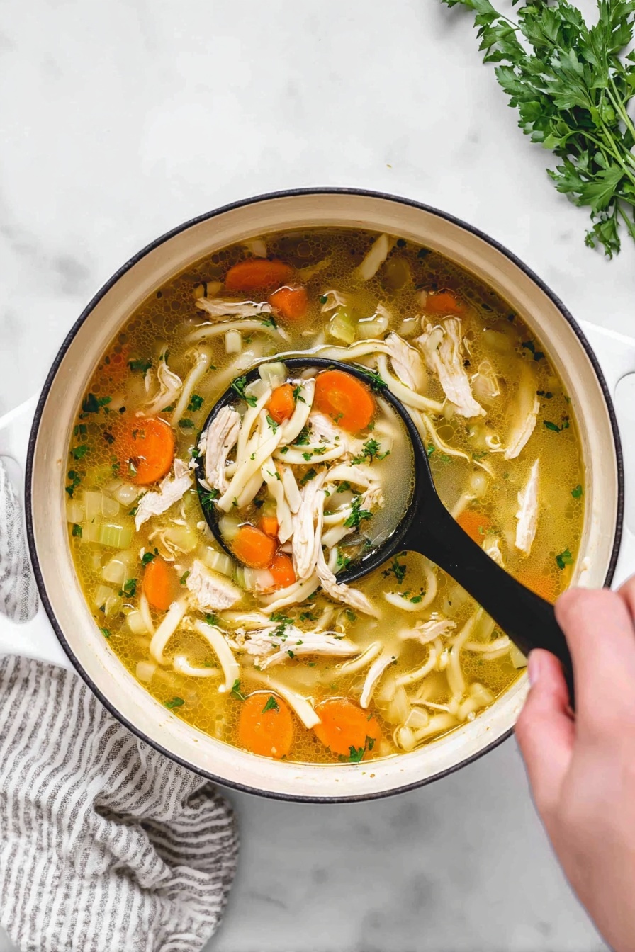chicken noodle soup - A white pot filled with a clear yellow broth soup that has many layers of ingredients: orange carrot slices, light green celery pieces, white thick noodles, and shredded white chicken pieces. There are small green herb pieces scattered on top. A woman’s hand is holding a black ladle lifting a portion of the soup, showing the carrots, noodles, chicken, and herbs clearly. The pot is placed on a white marbled surface with a white and gray striped cloth near the pot. Some green herbs are in the top right corner. photo taken with an iphone --ar 2:3 --v 7