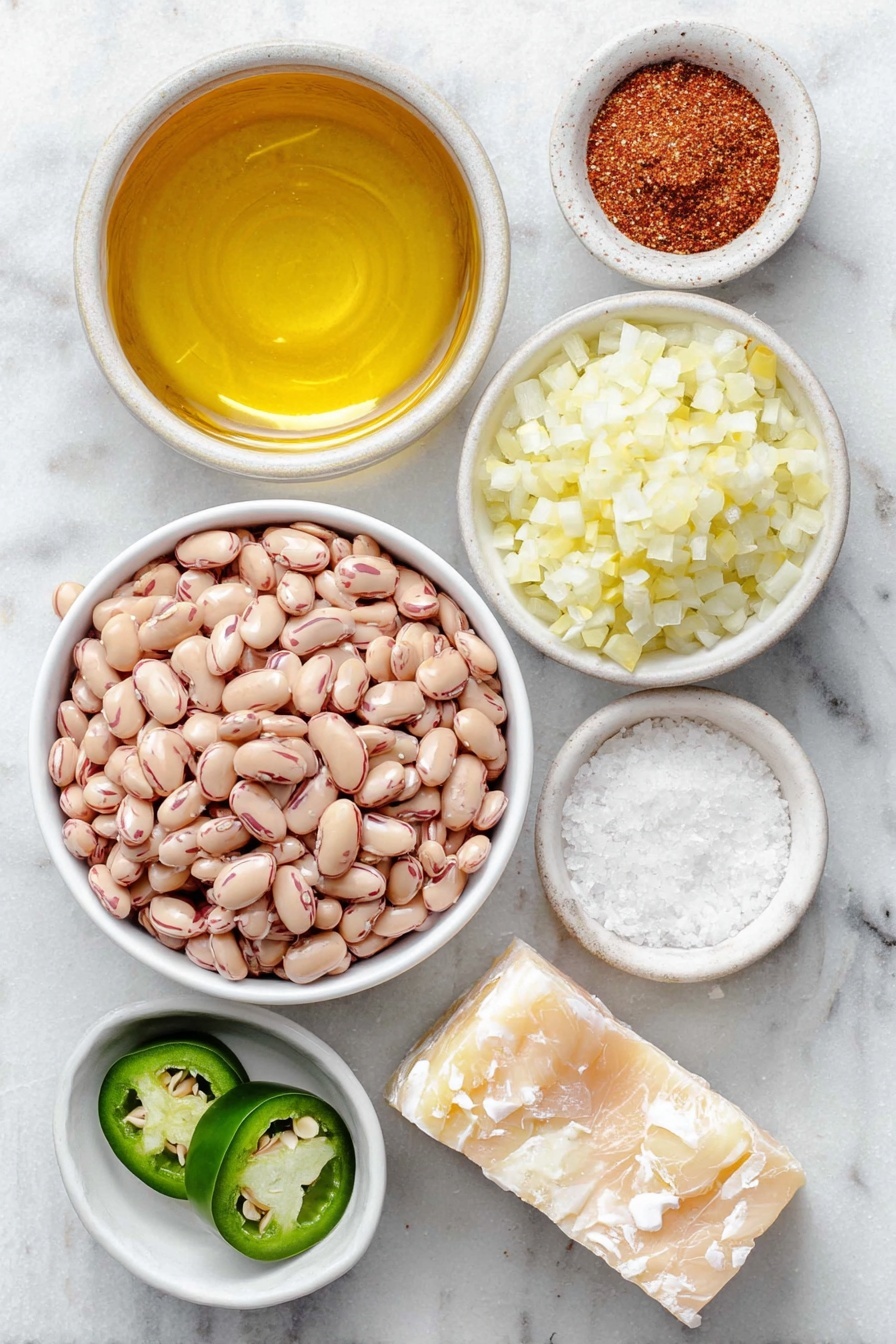 Flat lay of a small white ceramic bowl of golden corn oil, a small mound of diced yellow onion, half a fresh green jalapeño sliced, a small white bowl filled with dried pinto beans, a small white bowl with rich chicken broth, a small white bowl of coarse salt, a small white bowl of pale garlic powder, a small white bowl of deep red chili powder, and a small chunk of natural white lard placed on a clean white marble surface, soft natural light, photo taken with an iPhone, professional food photography style, fresh ingredients, white ceramic bowls, no bottles, no duplicates, no utensils, no packaging --ar 2:3 --v 7 --p awthu7i m7354615311229779997