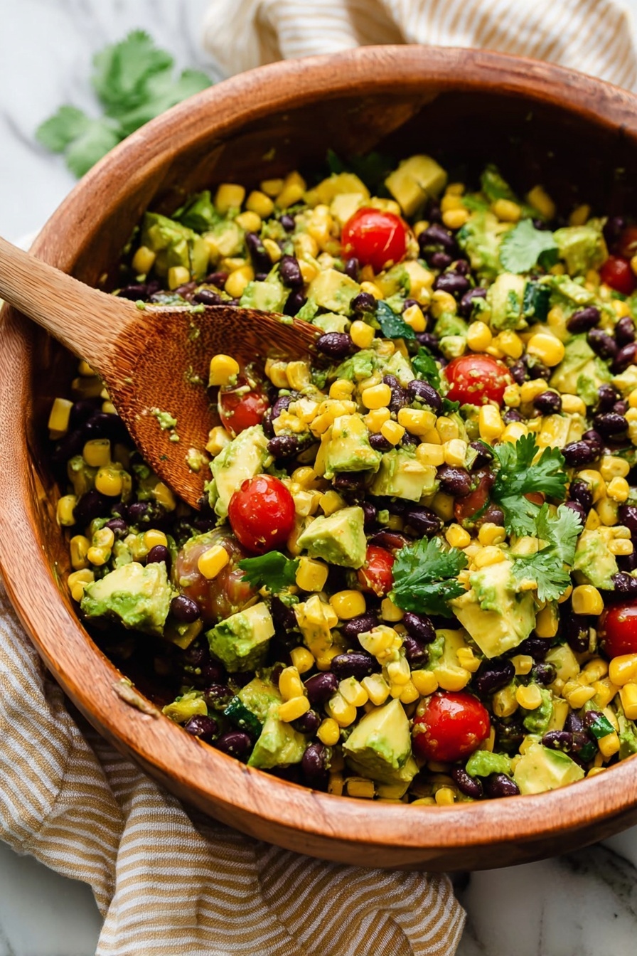 This image shows a close-up of a wooden bowl filled with a colorful salad containing four main layers: the first layer is yellow corn kernels spread all over, the second layer has black beans mixed evenly, the third layer consists of bright red cherry tomatoes, some whole and some halved, scattered throughout, and the fourth layer is made up of chunks of green avocado and fresh cilantro leaves on top. A wooden spoon with some of the salad on it is resting inside the bowl, lifting a mix of the ingredients. The background shows a white marbled surface with a beige cloth partially visible. The photo taken with an iphone --ar 2:3 --v 7