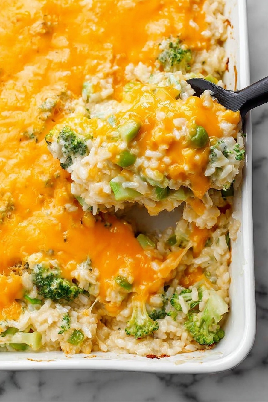 This image shows a thick layer of melted bright orange cheese spread evenly on top of a dish. Below the cheese is a mix of white rice, small green broccoli pieces, and some pale green chunks, all combined together. The dish is in a white rectangular ceramic baking pan with a smooth edge. A black serving spatula is lifting a portion from the corner, showing the gooey, mixed texture underneath with the cheese stretching slightly. The background is a white marbled surface. photo taken with an iphone --ar 2:3 --v 7