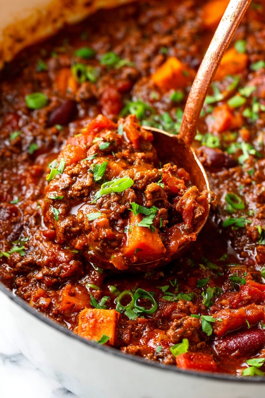 This image shows a close-up of a thick stew with a rich, dark reddish-brown sauce filled with ground meat, chunks of orange sweet potatoes, and pieces of red tomatoes. Bright green chopped herbs and sliced green onions are sprinkled evenly on top, adding a fresh contrast. A copper-colored ladle dips into the stew, lifting a spoonful packed with the chunky ingredients. The stew is in a white pot that is set on a white marbled surface, enhancing the vibrant colors of the food photo taken with an iphone --ar 2:3 --v 7