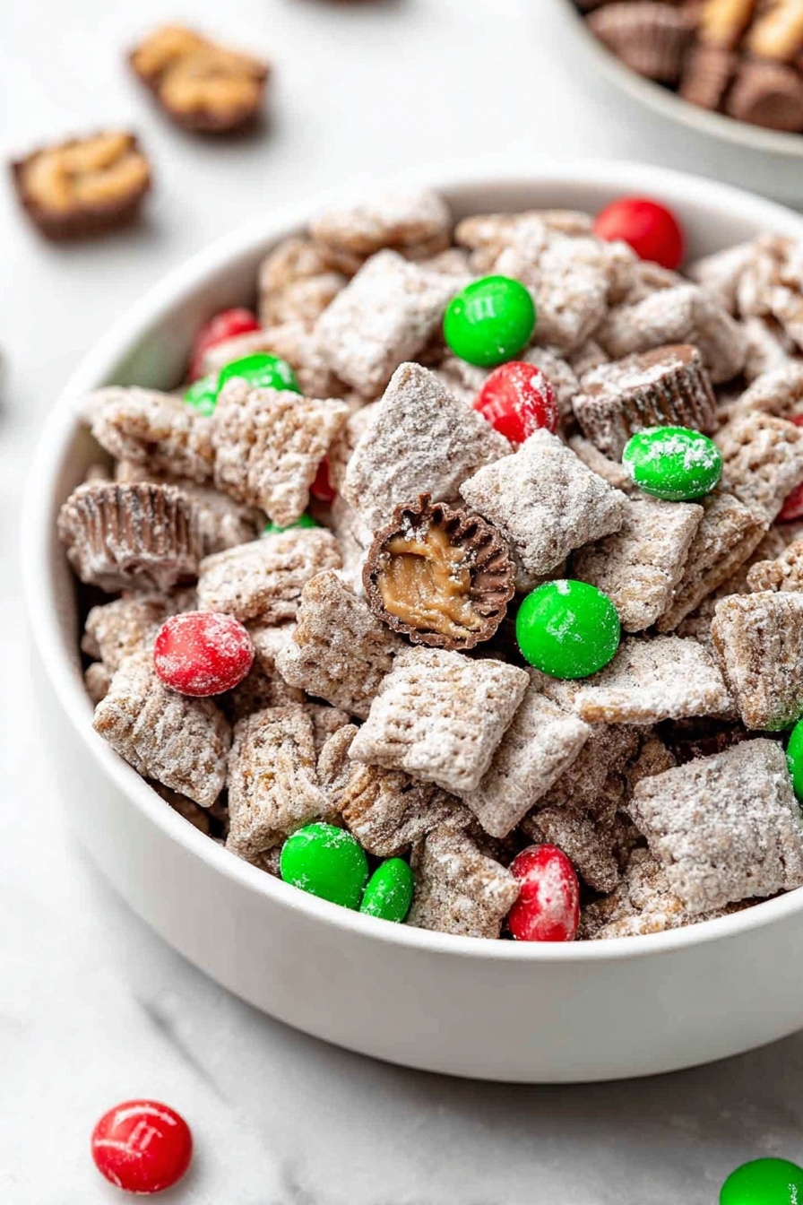 This image shows a white bowl filled with a mix of small square and round cereal pieces covered in a light dusting of powdered sugar, giving them a slightly rough texture. Scattered throughout the bowl are bright green and red candy-coated chocolate pieces that add pops of color against the mostly brown and white cereal. Some whole and broken miniature peanut butter cups are also mixed in, showing smooth chocolate surfaces and ridged edges. The bowl is set on a white marbled surface with a few candies and peanut butter cups placed nearby for decoration. photo taken with an iphone --ar 2:3 --v 7