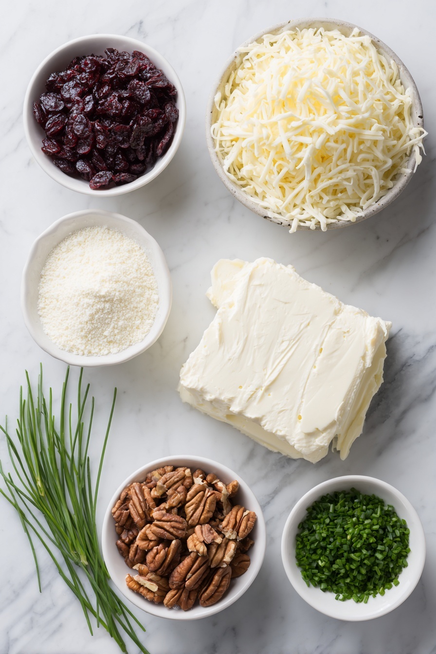 Flat lay of a small block of fresh cream cheese, a neat pile of shredded white sharp cheddar cheese, a small white ceramic bowl of chopped dried cranberries, a small white ceramic bowl of toasted chopped pecans, a small bunch of vibrant green chopped chives, and a small white ceramic bowl of fine garlic powder, all arranged symmetrically on a clean white marble surface, soft natural light, photo taken with an iPhone, professional food photography style, fresh ingredients, white ceramic bowls, no bottles, no duplicates, no utensils, no packaging --ar 2:3 --v 7 --p m7354615311229779997