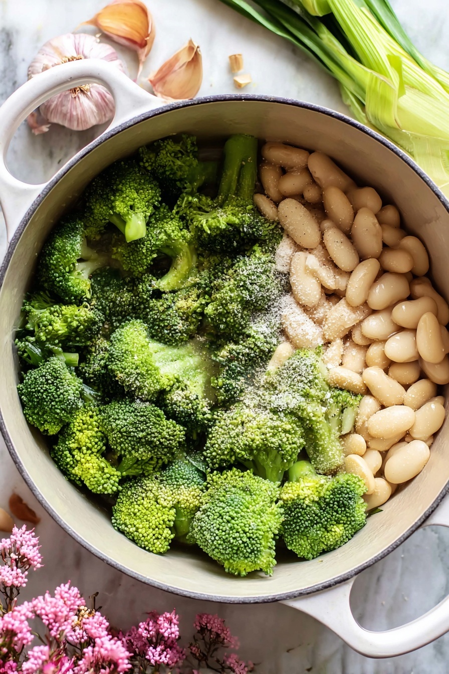 A white bowl with three main layers sits on a white marbled surface. The bottom layer is a thick, coarse green mixture that fills most of the bowl. On top of this is a round dollop of smooth white cream, placed slightly off-center. Surrounding the cream is a swirl of orange oil with a few small red chili slices and a bay leaf resting on the cream. On the right edge of the bowl is a knife with a white handle dipped into the green mixture. A piece of torn bread is visible in the top right corner. Photo taken with an iphone --ar 2:3 --v 7